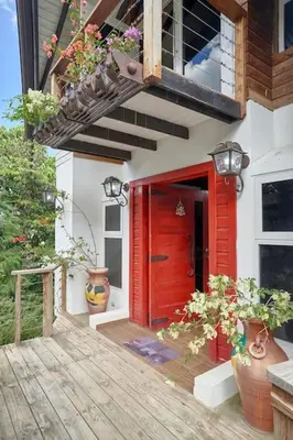 a red door on a house with potted plants at Mansion Dubai-Mountain-Jacuzzi-4BR-Jamaca De Dios in Jarabacoa