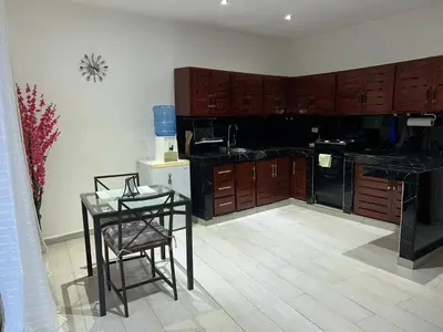 a kitchen with wooden cabinets and a table with a chair at Villa Kate in Las Terrenas