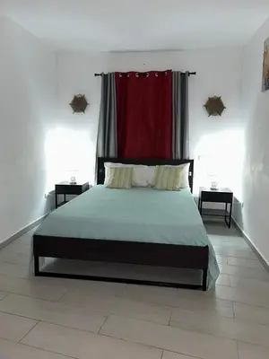 a bedroom with a large bed with a red curtain at Villa Kate in Las Terrenas