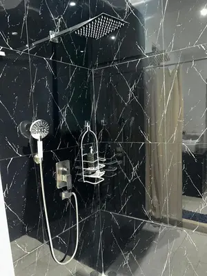 a bathroom with a shower with a black marble wall at Villa Kate in Las Terrenas