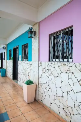 a building with colorful walls and a plant at Apartahotel Guaraguao in San Pedro de Macorís