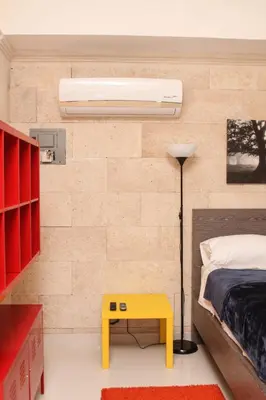 a bedroom with a bed and a yellow table at Apartahotel Guaraguao in San Pedro de Macorís