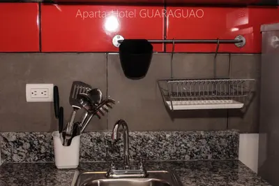 a kitchen sink with a faucet and a shelf at Apartahotel Guaraguao in San Pedro de Macorís