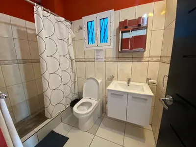 a small bathroom with a toilet and a sink at Apartahotel Guaraguao in San Pedro de Macorís