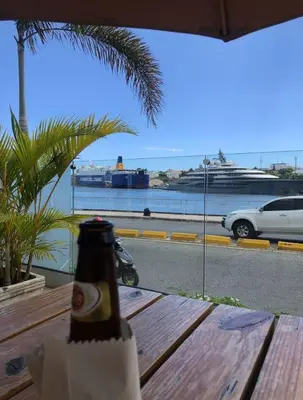 a bottle of beer sitting on a wooden table at Mirador Colonial, en el Residencial Riviera Colonial in Santo Domingo