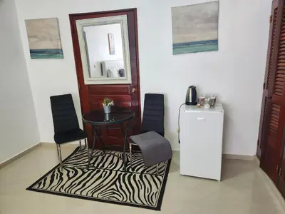 a room with a table and two chairs and a refrigerator at Million View Room Adults Only Resort 3 in La Laguna