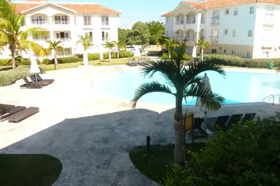 a palm tree in front of a swimming pool at Cadaques Caribe Boulevard Dominicus Americanus Carretera a Bayahibe Vel 206 in Bayahibe