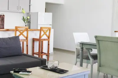 a living room with a couch and a table and chairs at Hotel Checkin El Cortecito Beach in Punta Cana