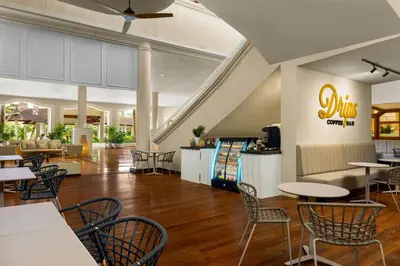 a restaurant with tables and chairs in a lobby at Wyndham Alltra Punta Cana All Inclusive Resort in Punta Cana