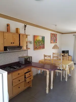 a kitchen with a table and a dining room at Las Palmeras RIKI R in Boca Chica