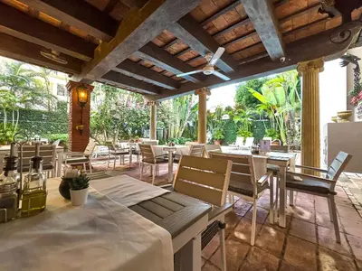 a restaurant with tables and chairs in a patio at Hotel San Marco in Santo Domingo