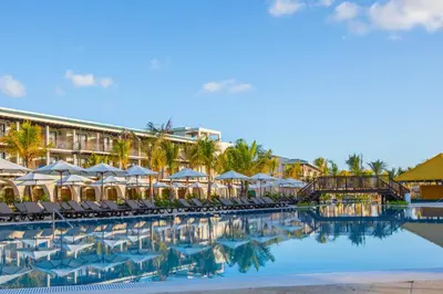 a pool at the resort with chairs and umbrellas at El Beso Adults Only At Ocean El Faro - All Inclusive in Punta Cana