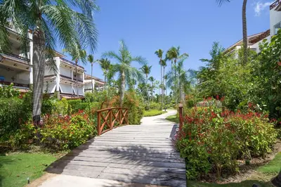 a walkway through a garden with palm trees and flowers at Xeliter Balcones del Atlantico - Las Terrenas in Las Terrenas