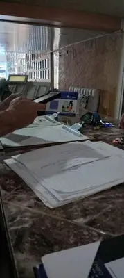 a person working on a table with papers on it at Hotel Frano Romana Center in La Romana