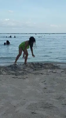 a young girl playing in the sand on the beach at TERRAZAS DEL CARIBE, APARTA HOTEL. in Santo Domingo