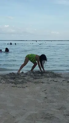 a woman is digging in the sand on the beach at TERRAZAS DEL CARIBE, APARTA HOTEL. in Santo Domingo