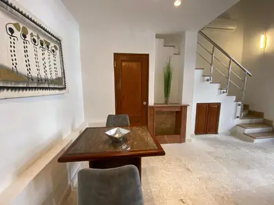 a dining room with a table and chairs and stairs at Paseo Colonial - Sanctuary #2 in Santo Domingo