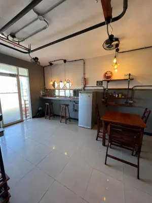 a room with a table and a kitchen with a refrigerator at Hostel Eco Punta Cana in Punta Cana