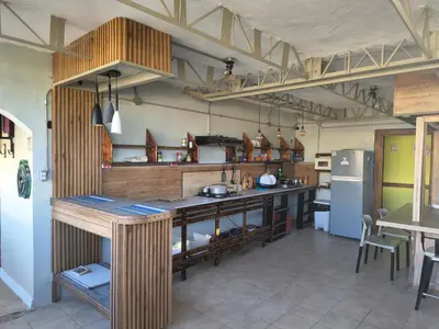 a large kitchen with a counter and a refrigerator at Hostel Eco Punta Cana in Punta Cana
