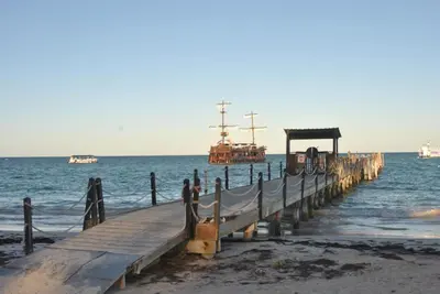 a wooden pier with a boat in the water at Hostel Eco Punta Cana in Punta Cana