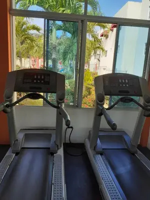 a gym with two treadmills and a window at SANTIAGO CITY in Santiago de los Caballeros