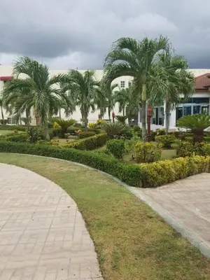 a park with palm trees in front of a building at SANTIAGO CITY in Santiago de los Caballeros