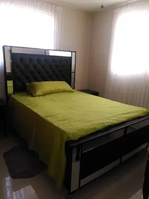a bedroom with a bed with a green bedspread and a window at SANTIAGO CITY in Santiago de los Caballeros