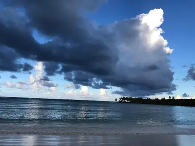 a cloudy sky over the water on a beach at Casa Azul Las Galeras in Las Galeras