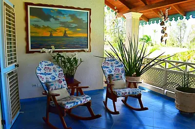 two chairs sitting on a porch with a painting at La Dolce Vita 12 Beachfront Hotels, Las Terrenas, Samana in Las Terrenas