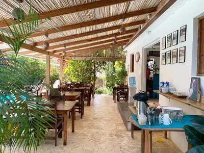 a restaurant with wooden tables and chairs and plants at Surfbreak B&B in Cabarete