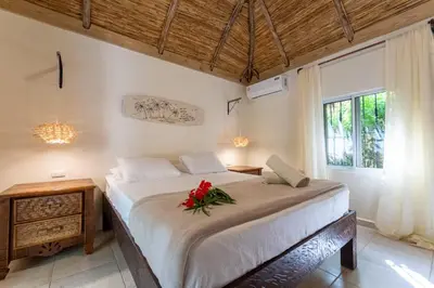 a bedroom with a bed with a flower on it at Surfbreak B&B in Cabarete