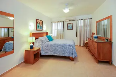 a bedroom with a bed and a dresser and a mirror at Cabarete Palm Beach Condos in Cabarete