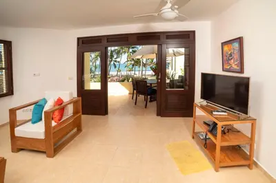 a living room with a television and a table at Cabarete Palm Beach Condos in Cabarete