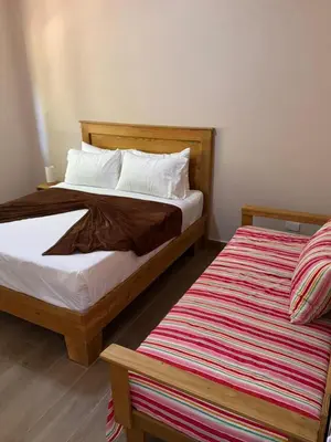 a bedroom with two beds and a striped rug at Gipsy Ranch Rooms in Cabarete