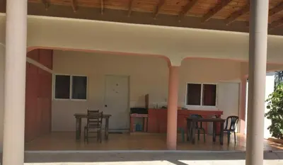an empty room with tables and chairs in a house at Gipsy Ranch Rooms in Cabarete