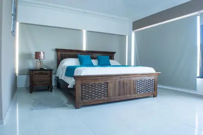 a bedroom with a large bed with blue pillows at Malecon Rooms y Hotel in Santo Domingo