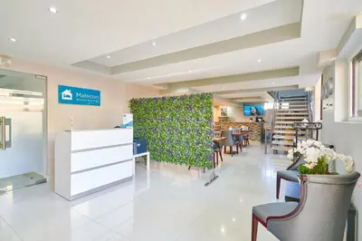 a waiting room with a green wall and chairs at Malecon Rooms y Hotel in Santo Domingo