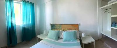 a bedroom with a bed with blue pillows and a window at Villa Florencia Vip in Punta Cana