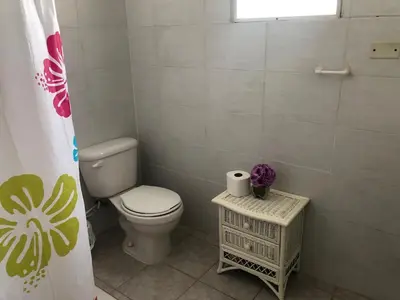 a small bathroom with a toilet and a window at Villa Florencia Vip in Punta Cana