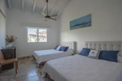 a bedroom with two beds and a ceiling fan at Balcones Beach Penthouse in Las Terrenas