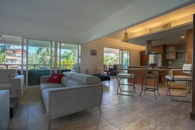 a living room with a couch and a kitchen at Balcones Beach Penthouse in Las Terrenas