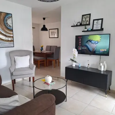a living room with a tv on a wall at Residencial Palmas De Gurabo in Santiago de los Caballeros