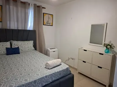 a bedroom with a bed and a television on a dresser at Residencial Palmas De Gurabo in Santiago de los Caballeros