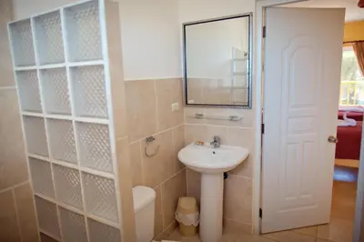 a small bathroom with a sink and a mirror at Kite Beach Inn in Cabarete