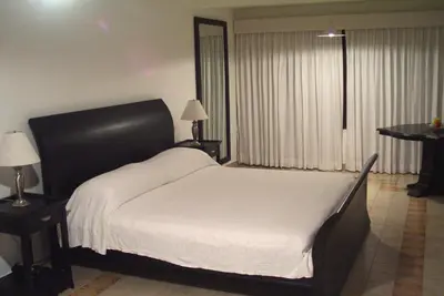 a bedroom with a large white bed and a table at Sosua by the Sea in Sosúa