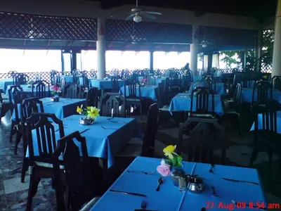 a restaurant with blue tables and chairs with flowers on them at Sosua by the Sea in Sosúa