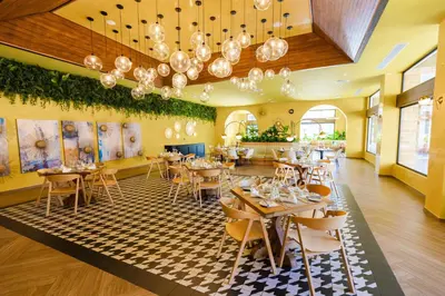 a restaurant with tables and chairs in a room at Tropical Deluxe Princess - All Inclusive in Punta Cana