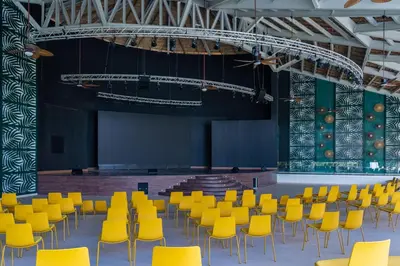 a large room with yellow chairs and a stage at Tropical Deluxe Princess - All Inclusive in Punta Cana