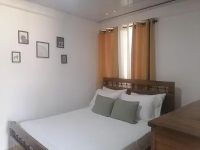 a bedroom with a bed with white sheets and pillows at J. B Apartamentos in Santo Domingo