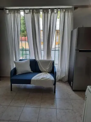 a blue couch sitting in front of a window at J. B Apartamentos in Santo Domingo